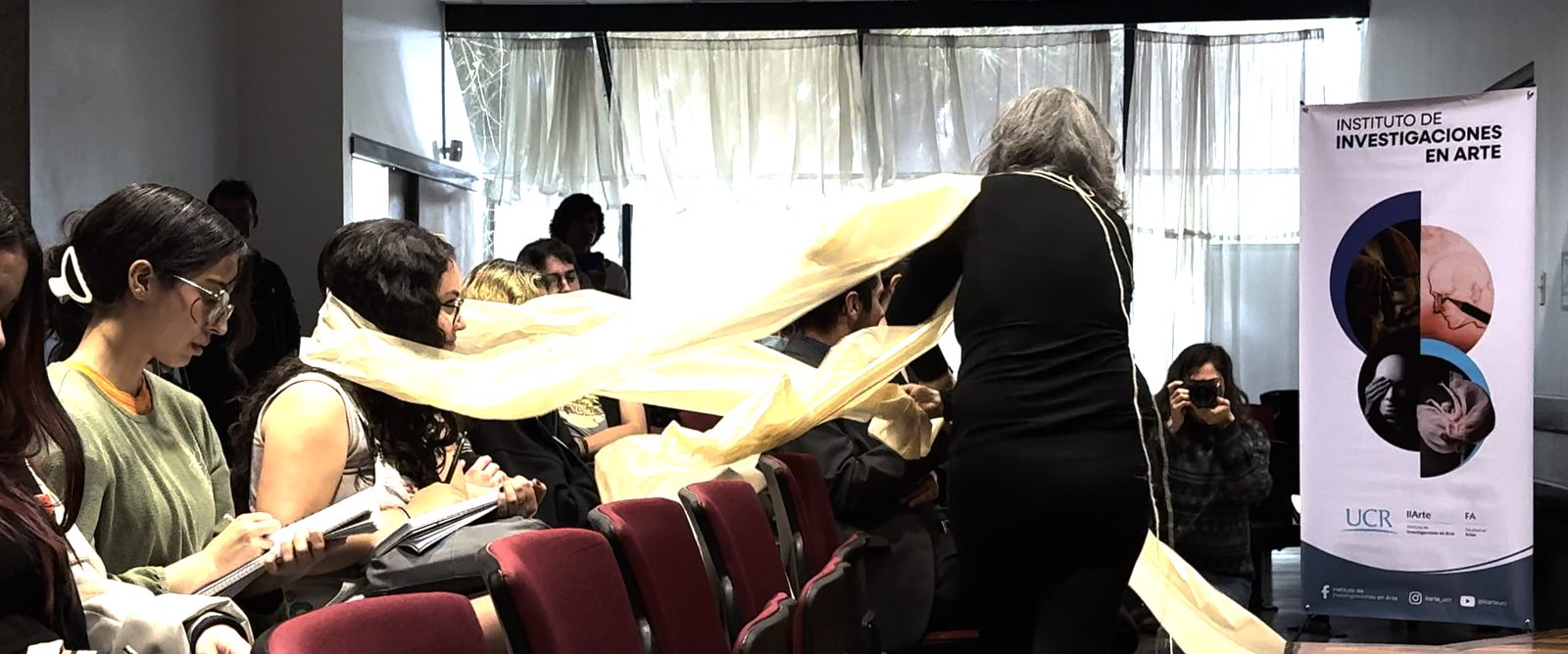 Convergences, 2025, performance: the artist draws a long paper ribbon across the audience